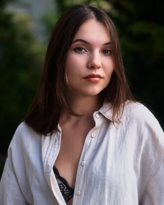 Portret Aidy w białej koszuli na tle zieleni, sesja portretowa Wrocław