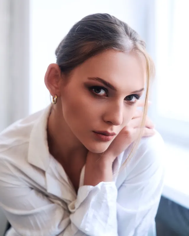 Portret Ani w białej koszuli opierającej twarz na dłoni, sesja portretowa Wrocław