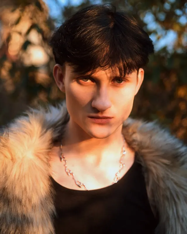 Portret Jakuba w futrze i z naszyjnikiem w złotym świetle zachodu słońca, sesja portretowa Wrocław