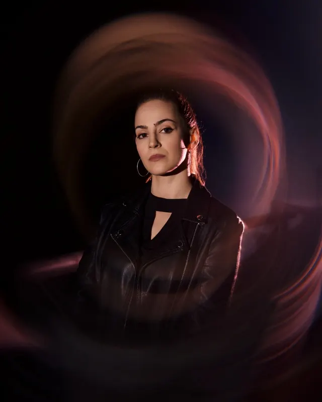 Portret Magdy w skórzanej kurtce z efektem light painting na ciemnym tle, sesja portretowa Wrocław