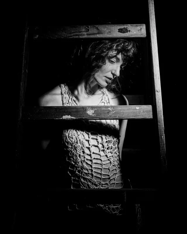 Czarno-biały portret Pauliny w siatkowej bluzce za drabiną, artystyczna sesja Wrocław