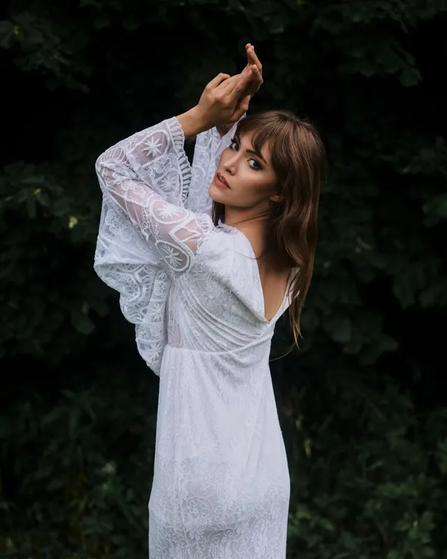 Wiktoria w białej koronkowej sukni plenerowej na tle zieleni, sesja portretowa Rzeszów