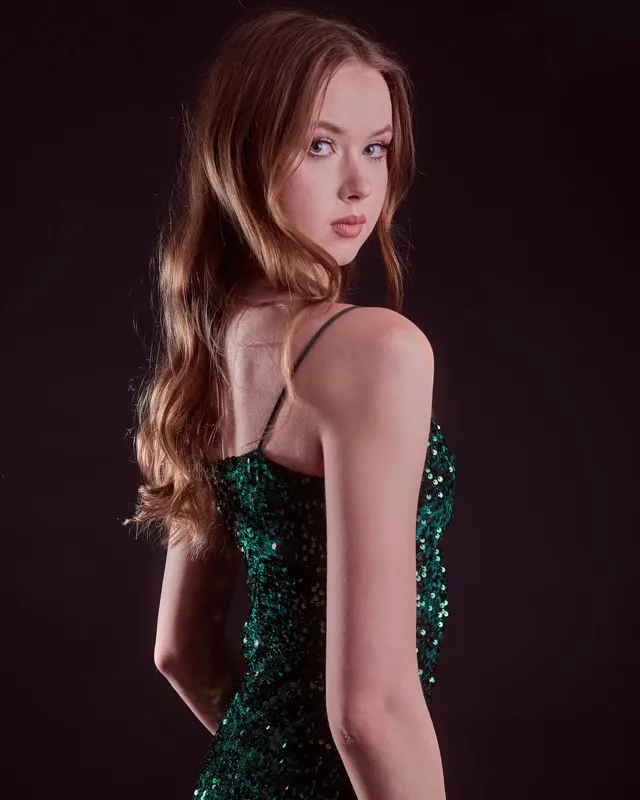 Zuzanna w zielonej cekinowej sukience na ciemnym tle, elegancka sesja portretowa Wrocław